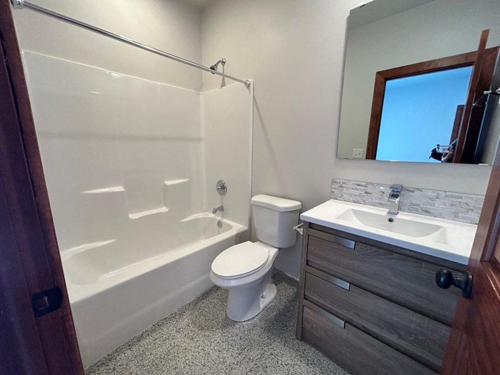 a bathroom with a toilet and a tub and a sink