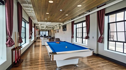 a games room with a pool table in the middle of it