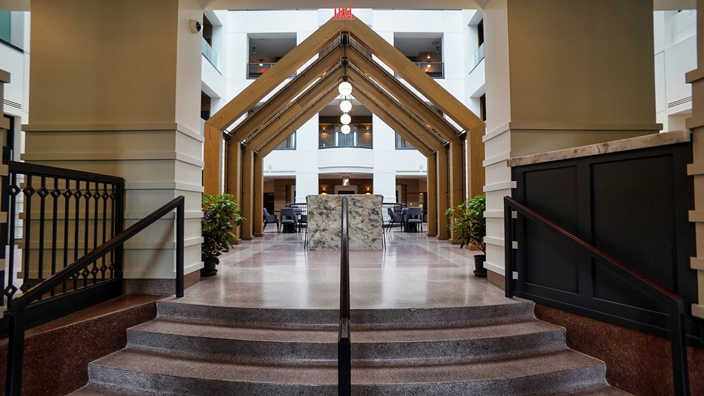 a view of the lobby of a building with stairs and a table in the center