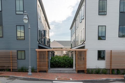a building with a wooden gate between two buildings