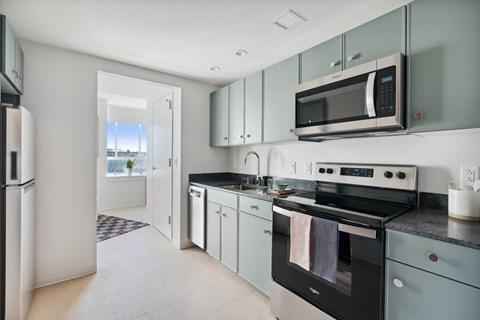 a modern kitchen with stainless steel appliances and white cabinets