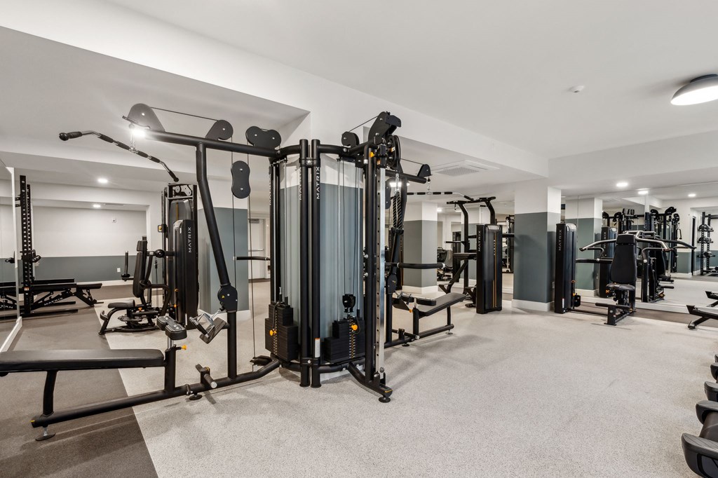a gym with weights and exercise equipment in a building with white walls
