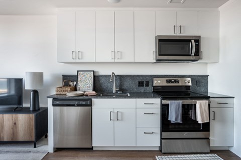 a kitchen with white cabinets and stainless steel appliances