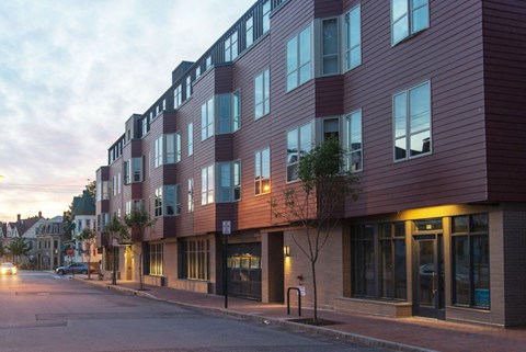 a new building on a city street at dusk