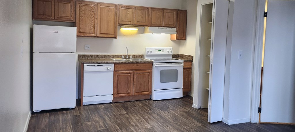 a kitchen with white appliances and wooden cabinets