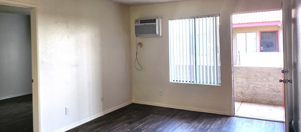 an empty room with a window and an air conditioner