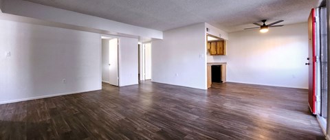an empty living room with white walls and wood laminate floors