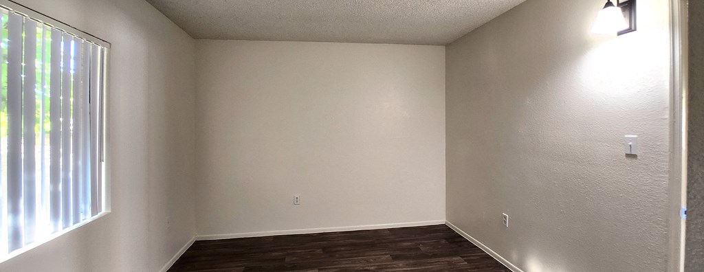 a bedroom with white walls and a large window