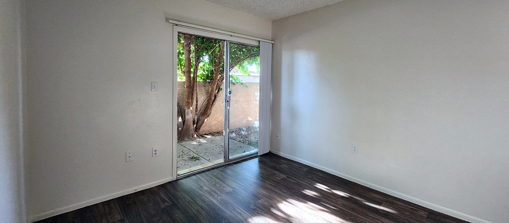 a bedroom with hardwood floors and white walls
