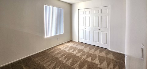 a bedroom with a closet and a window and a door