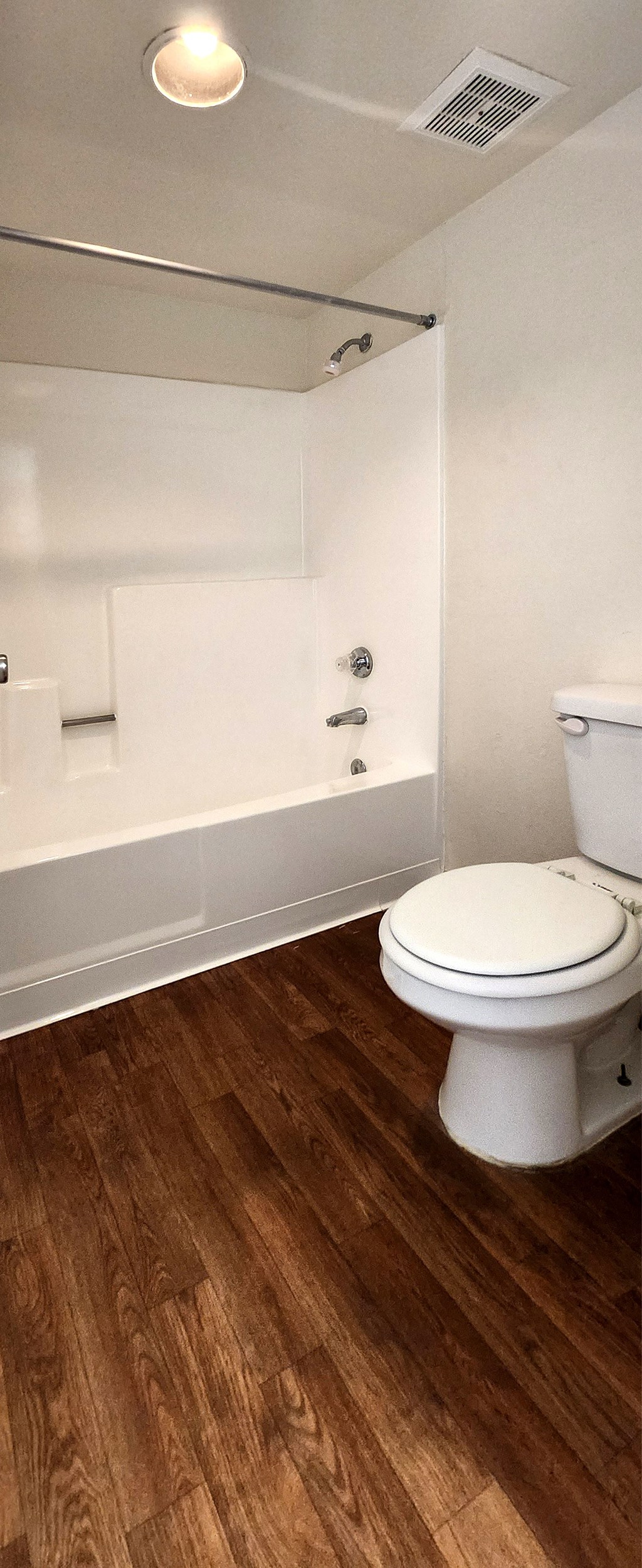 a bathroom with a toilet and a combination shower/bathtub