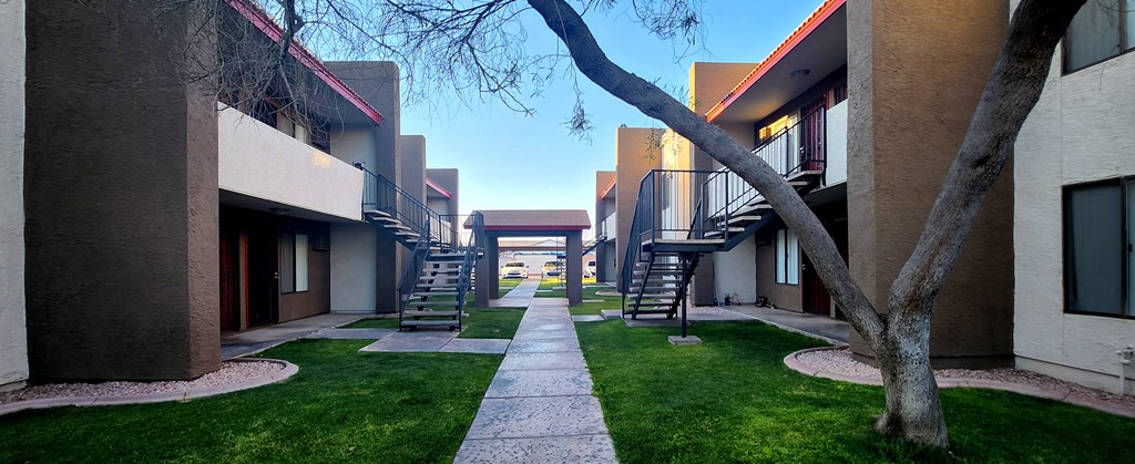a walkway between two buildings on a sunny day