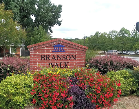 a brick sign in front of a garden