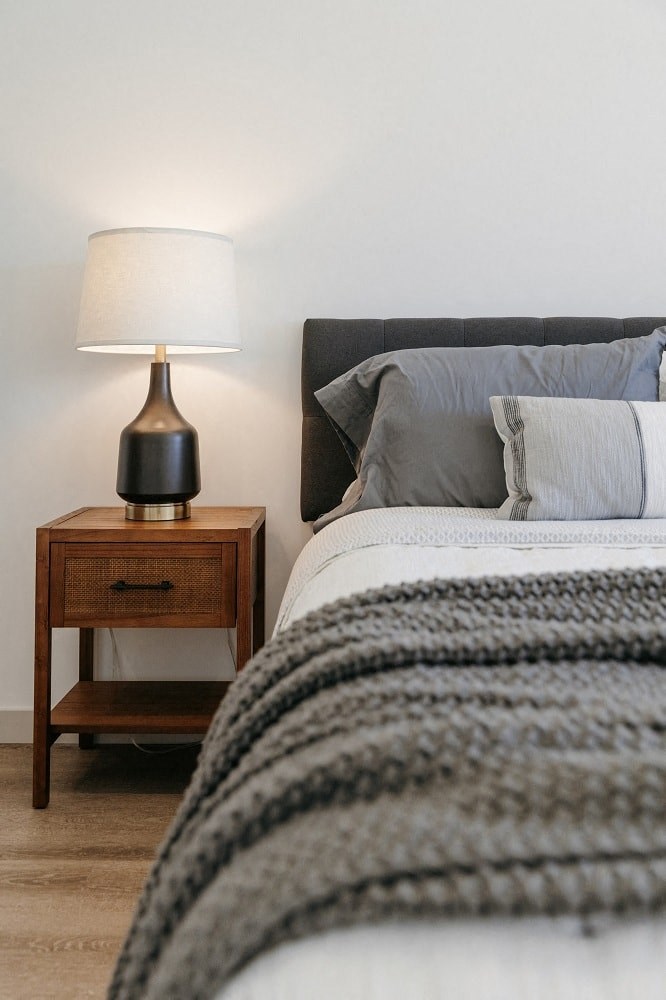 a bedroom with a bed and a table with a lamp