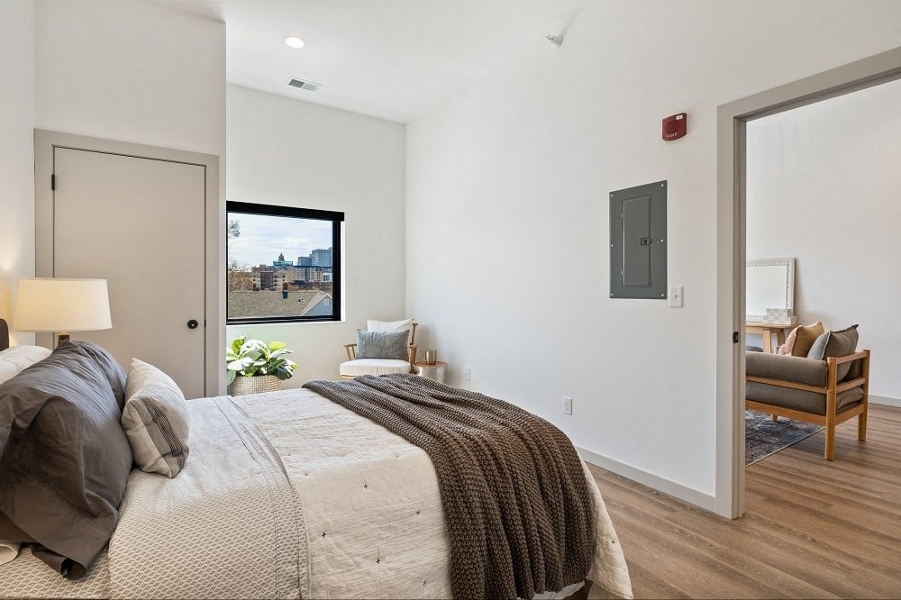 a bedroom with a bed and a door to a living room