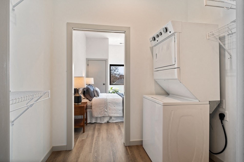 a kitchen with white appliances and a bedroom with a bed