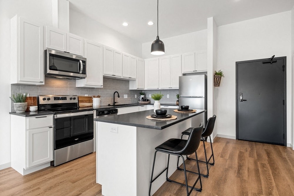 an open kitchen with an island with two chairs
