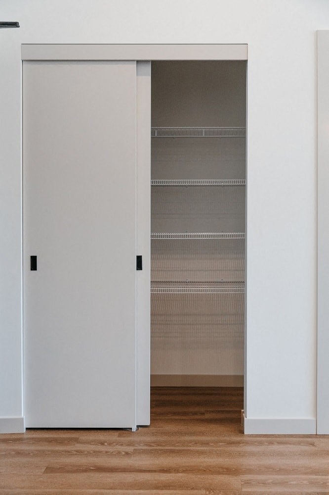 a closet with an open door and a wooden floor