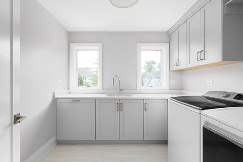 A kitchen with white cabinets and a black dishwasher.
