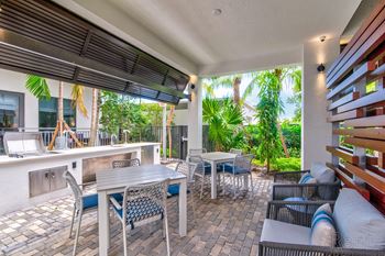 A patio with a table and chairs is covered by a roof at Mayla Pompano, Pompano Beach, 33062
