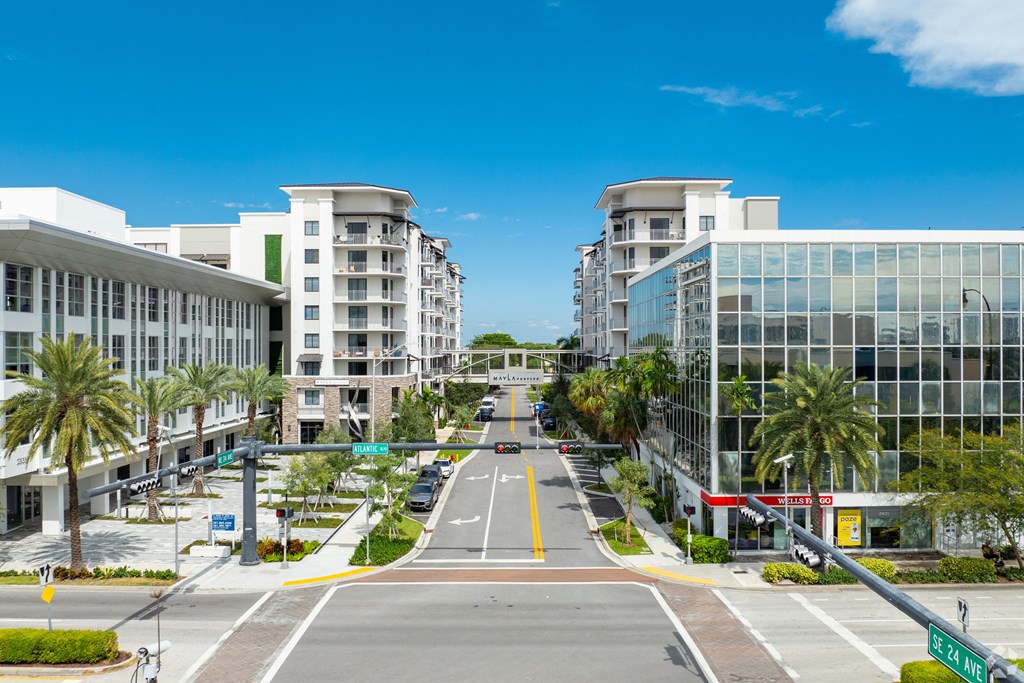 A street view of a residential area with modern buildings and palm trees at Mayla Pompano, Pompano Beach, Florida, 33062