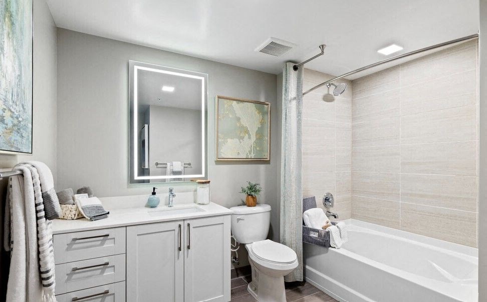 a bathroom with a tub sink toilet and a mirror at Mayla Pompano, Pompano Beach, 33062