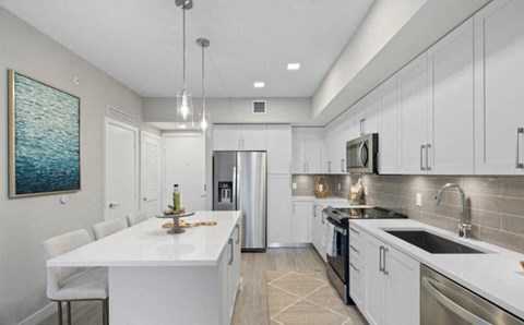 a white kitchen with a sink and a refrigerator