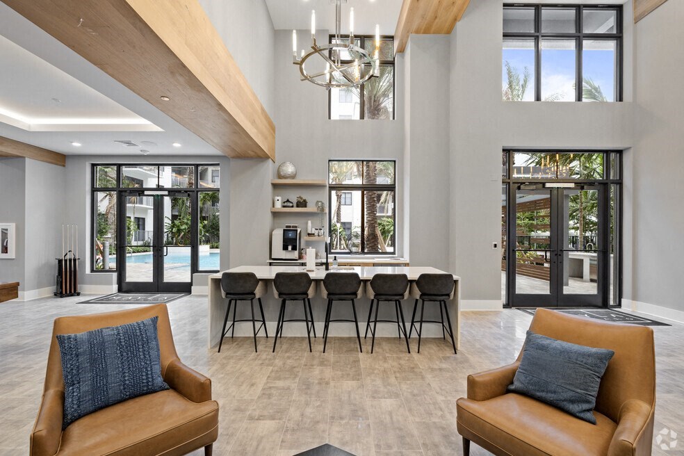 a living room with a bar and chairs and a kitchen with a pool at Mayla Pompano, Pompano Beach, 33062
