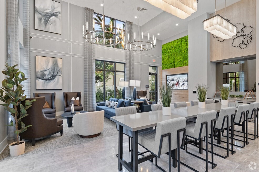 a dining room and living room with a long table and chairs at Mayla Pompano, Pompano Beach, FL, 33062