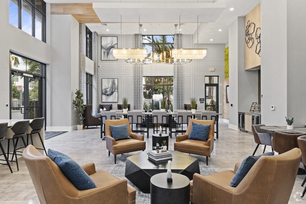 a living room with chairs and tables and a large window at Mayla Pompano, Pompano Beach, 33062