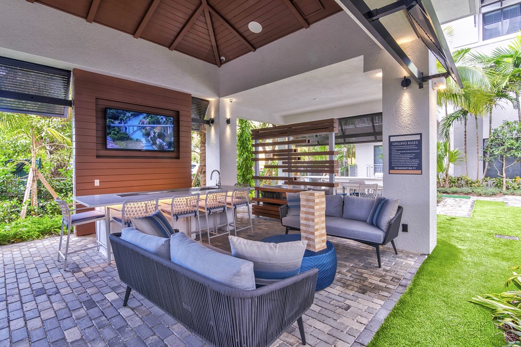 A patio with a grey couch and a wooden television at Mayla Pompano, Pompano Beach, 33062