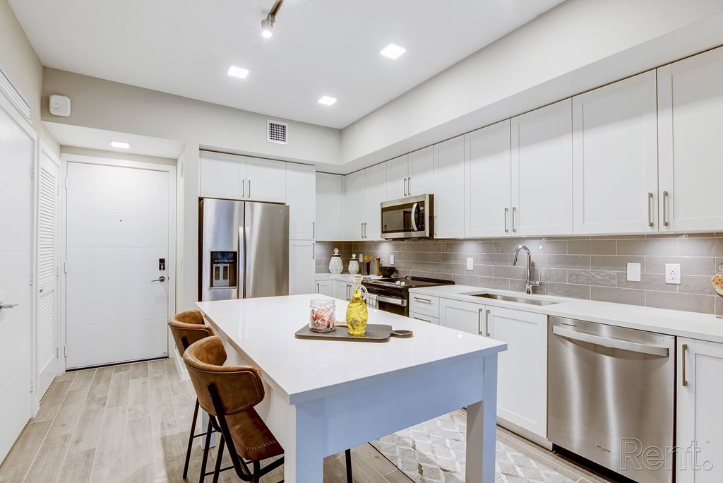 A kitchen with a white table and stainless steel appliances at Mayla Pompano, Pompano Beach, FL