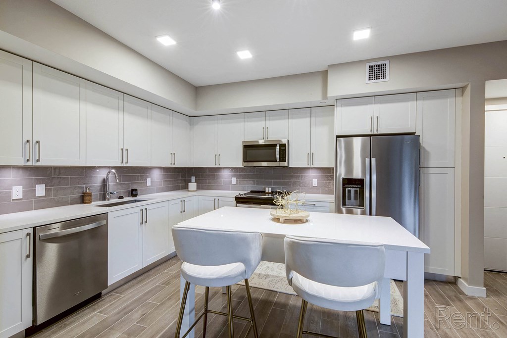 A modern kitchen with a white table and chairs at Mayla Pompano, Pompano Beach, Florida