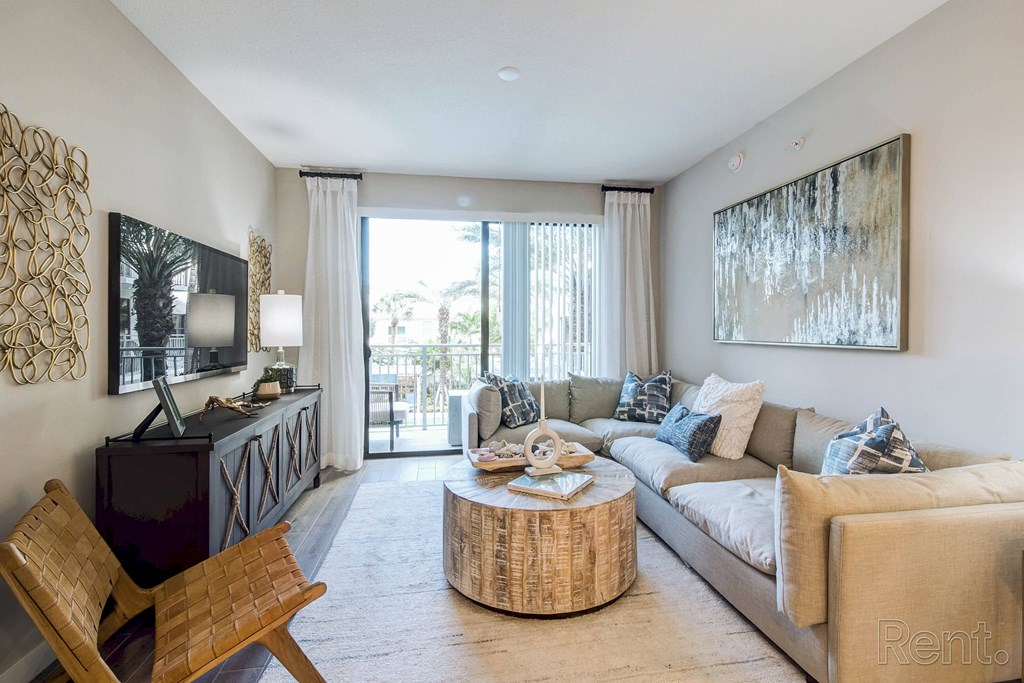 A living room with a wooden chair and a white couch at Mayla Pompano, Pompano Beach, 33062