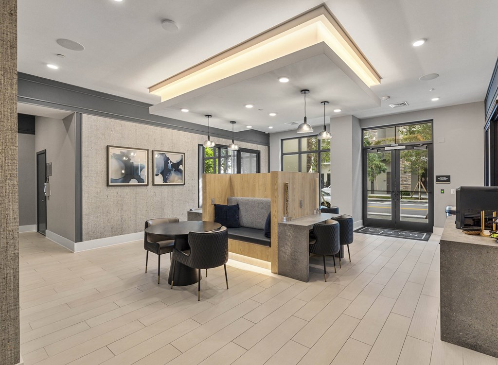 A modern office lobby with a reception desk and seating area at Mayla Pompano, Pompano Beach, 33062