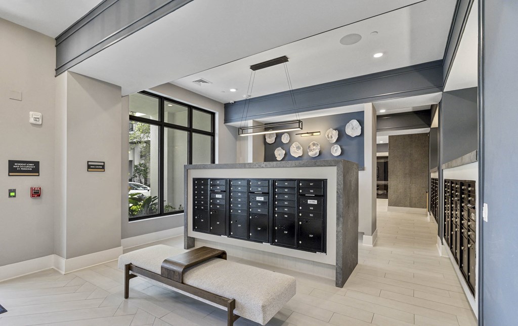 A modern waiting room with a bench and a wall of lockers at Mayla Pompano, Pompano Beach, Florida