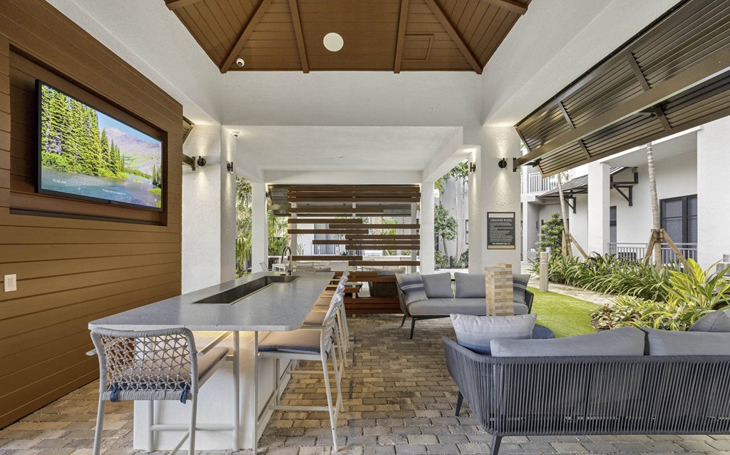 A modern outdoor dining area with a table and chairs at Mayla Pompano, Pompano Beach, FL, 33062
