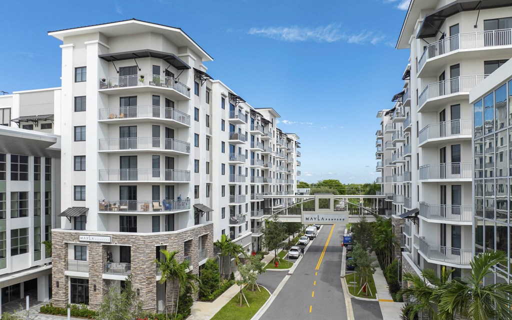 A street view of a residential area with apartment buildings on both sides at Mayla Pompano, Pompano Beach, FL