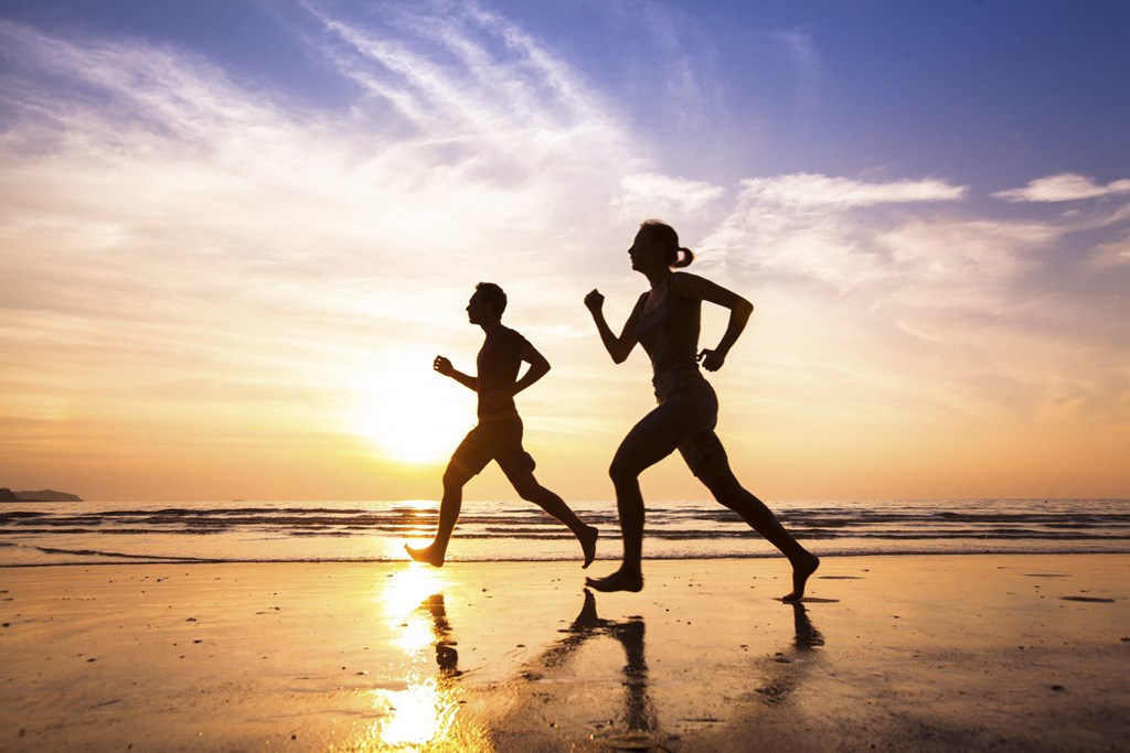 Two people running on the beach at sunset at Mayla Pompano, Pompano Beach, 33062