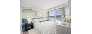 A bedroom with a large bed and a painting on the wall.