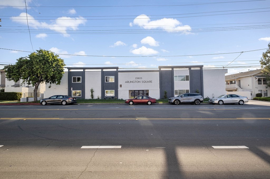 a white and gray building with cars parked in front of it at Arlington Square Apartment, Torrance, CA, 90501