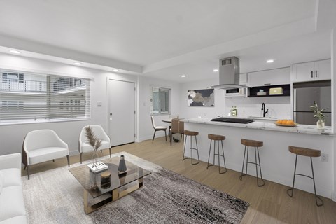 A modern kitchen with white cabinets and a bar area.
