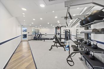 A gym with a variety of equipment including weights and machines.at The Reserve La Mirada, La Mirada, California