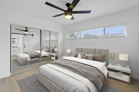 A bedroom with a large bed and a ceiling fan.