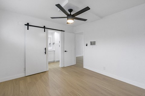 A room with a ceiling fan and wooden flooring. at Torrance Gateway Apartments, Torrance, California