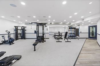 A spacious gym with a variety of equipment including treadmills, weights, and exercise machines.at The Reserve La Mirada, La Mirada, California