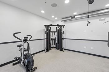 A gym room with a stationary bike and a weight machine.at The Reserve La Mirada, La Mirada, California