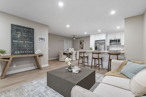 A living room with a coffee table and a chalkboard on the wall.