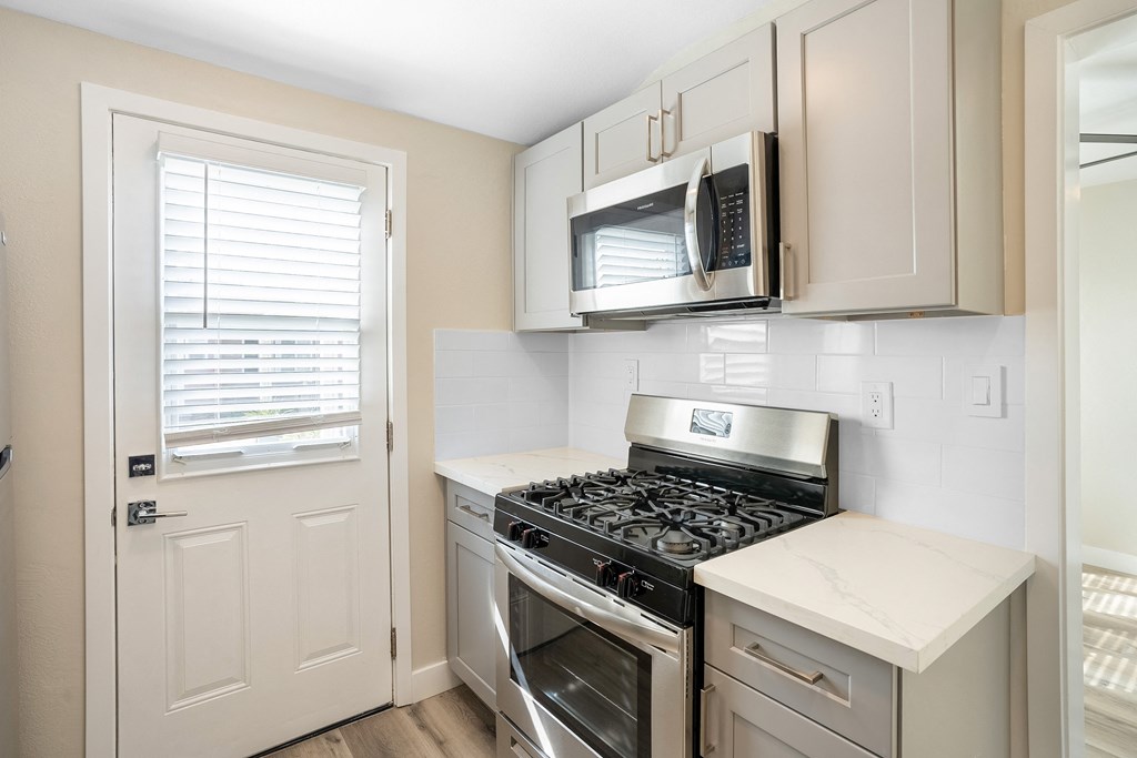 an empty kitchen with a stove and a microwave at Huntington Manor Homes Apartment, Huntington Beach, CA