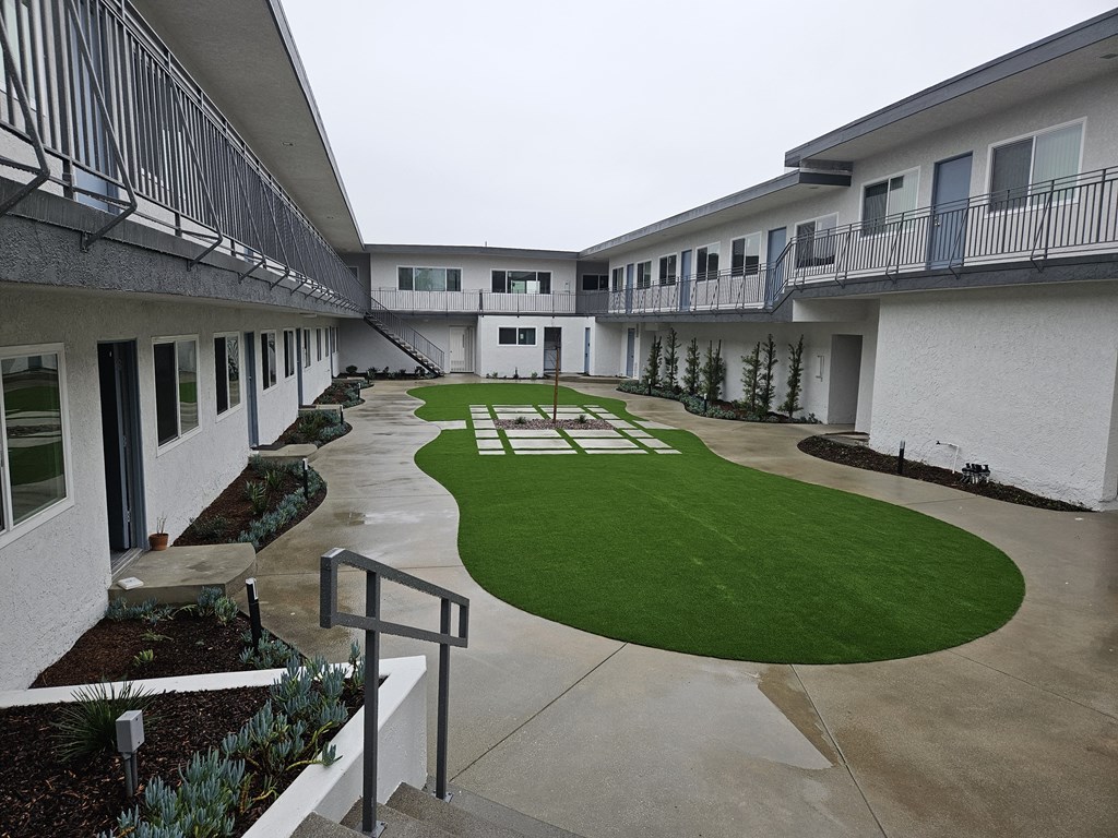 the courtyard of a condo building with a green lawn
